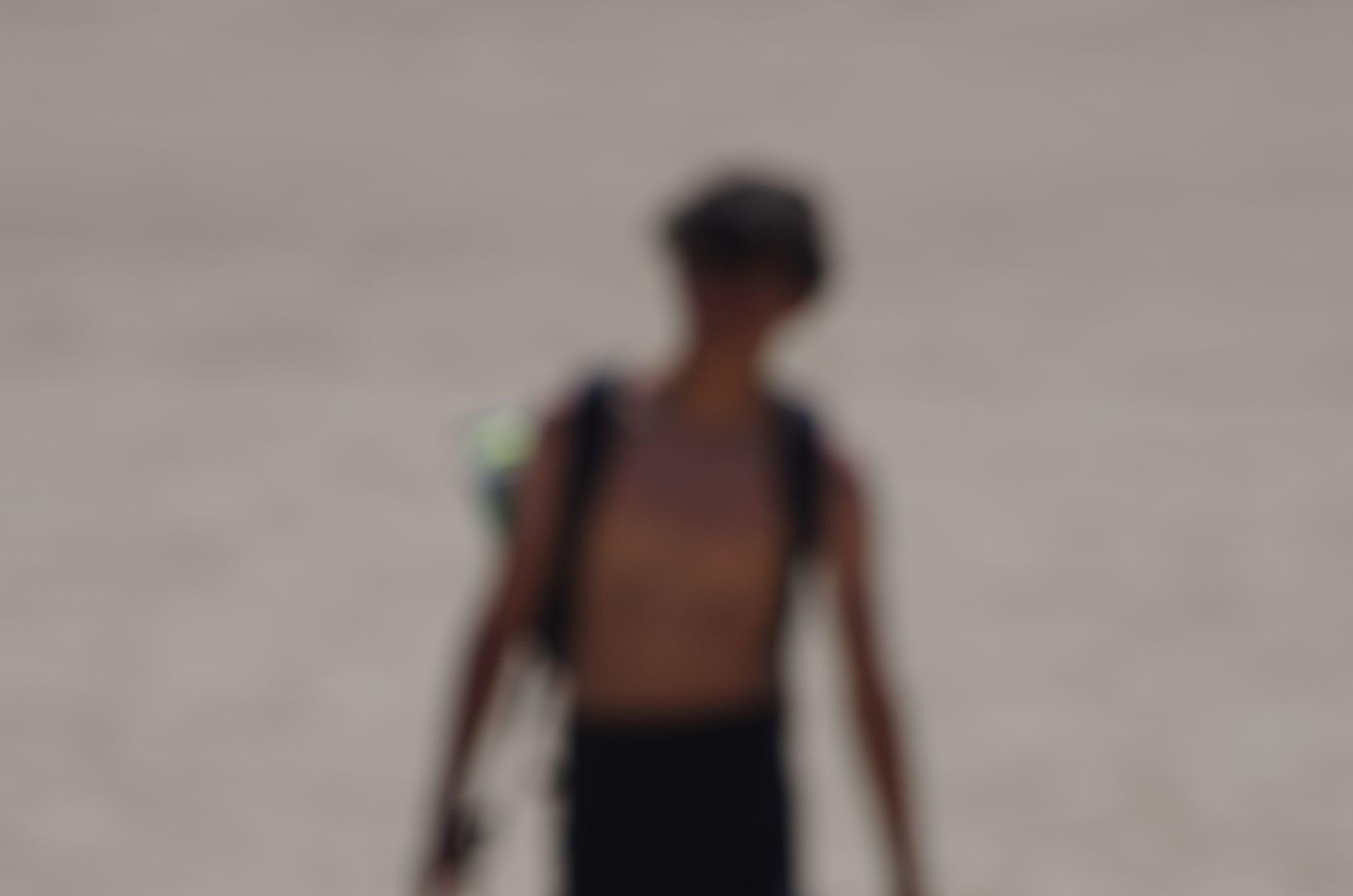 A figure walking across the sand, out of focus